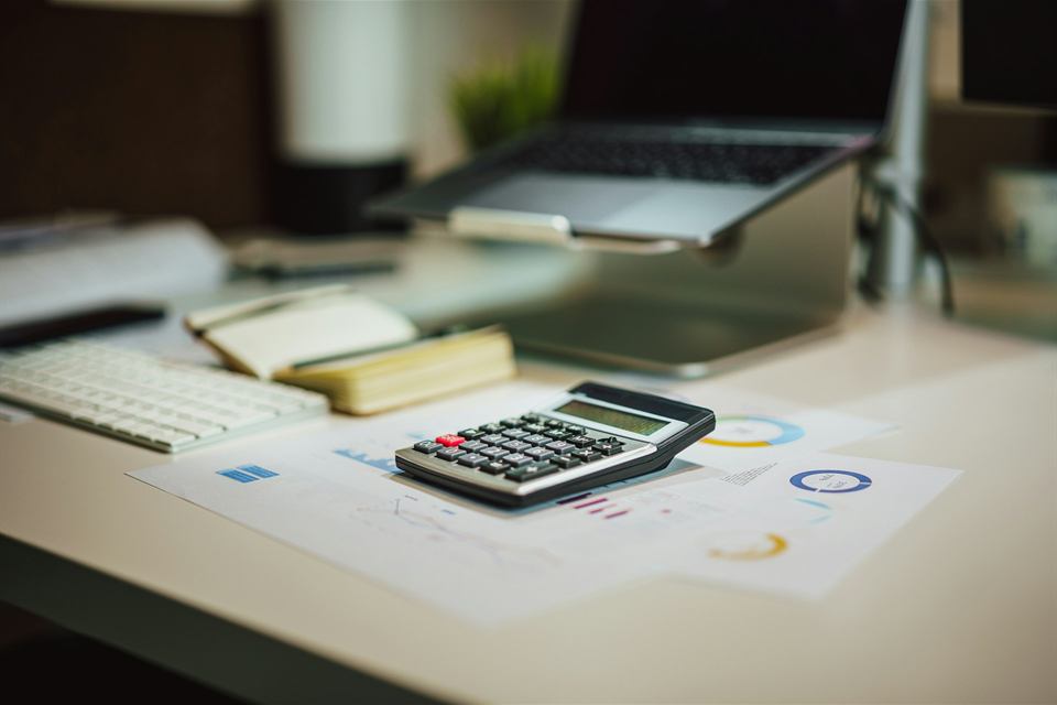 Calculator and laptop on a desk