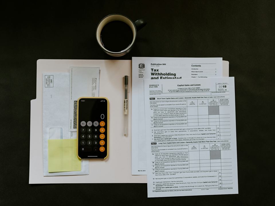 US tax forms, a calculator and coffee on a desk